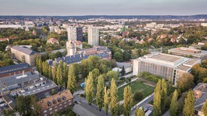 The photo shows an aerial view of some buildings of the TU Dresden. Among other things, you can see the auditorium center with its large meadow.