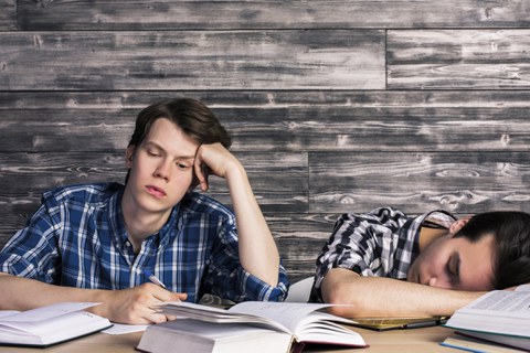 Two tired students at their desk